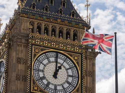 Primer plano del Big Ben de Londres con una bandera británica ondeando delante, Reino Unido