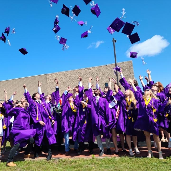 Estudiantes lanzando birretes en su graducación del high school en USA