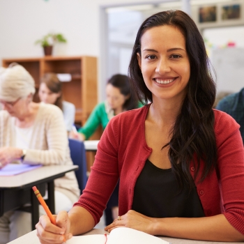 mujer adulta sentada en un puputre realizando una clase de inglés en el extranjero