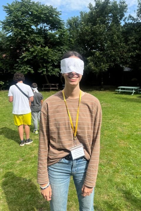 estudiante con los ojos vendados preparada para realizar un juego en grupo donde un compañero la tiene que guiar