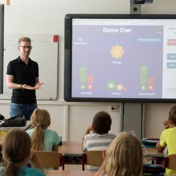 Profesor de primaria con pizarra interactiva
