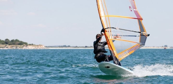 Chico del campamento de verano en la Rochelle realizando windsurf