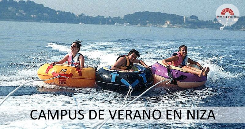 Tres chicas del campamento de verano en Niza realizando una actividad acuática en el mar subidas a unos flotadores gigantes.