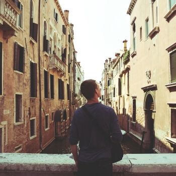 Joven admirando canal de Venecia