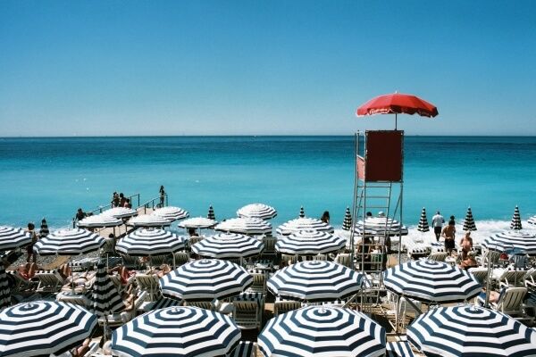 Playa de Niza con sombrillas de rallas azules y blancas
