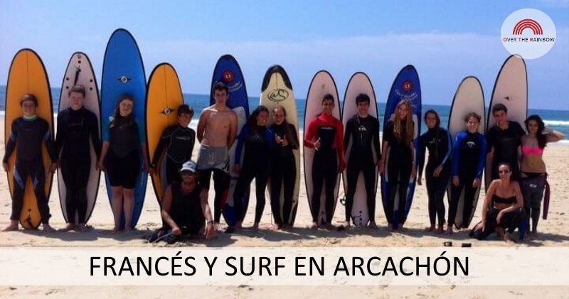 Participantes del campamento de surf y francés en Arcachón posando en la playa con sus tablas de surf detrás